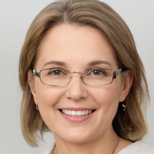 Joyful white adult female with medium  brown hair and grey eyes