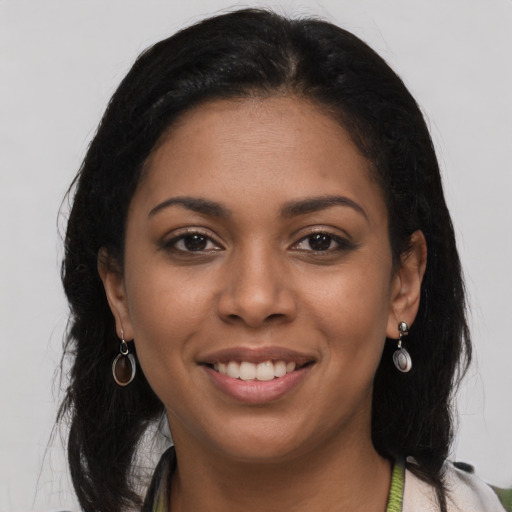 Joyful black young-adult female with long  brown hair and brown eyes