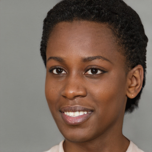 Joyful black young-adult female with short  brown hair and brown eyes