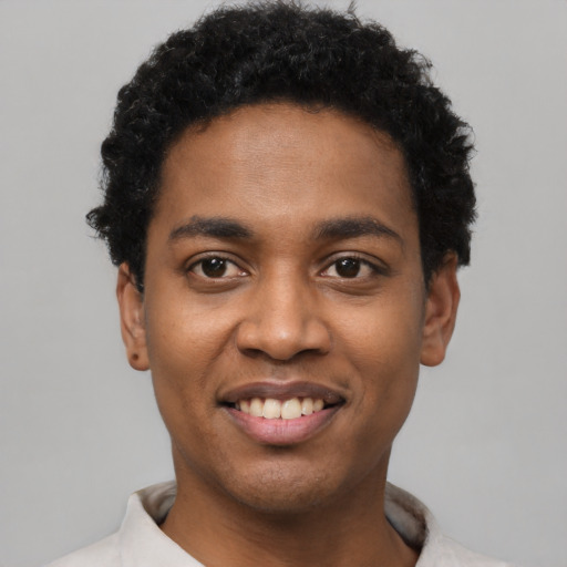Joyful black young-adult male with short  black hair and brown eyes