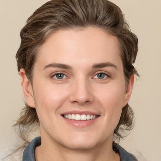 Joyful white young-adult female with medium  brown hair and grey eyes