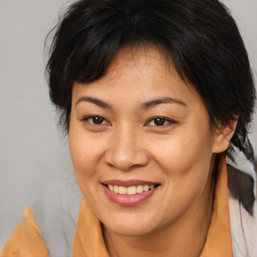 Joyful asian adult female with medium  brown hair and brown eyes