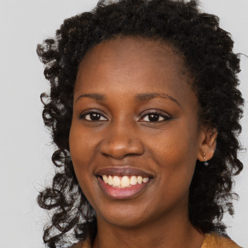 Joyful black young-adult female with long  brown hair and brown eyes