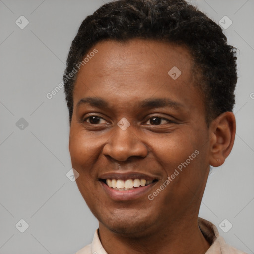 Joyful black young-adult male with short  brown hair and brown eyes