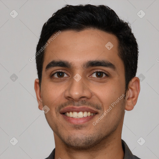 Joyful latino young-adult male with short  black hair and brown eyes