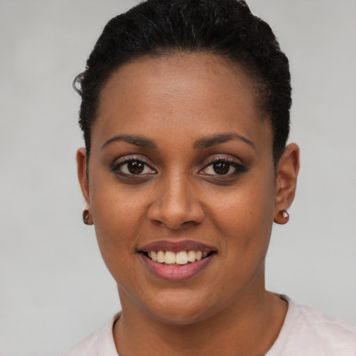 Joyful black young-adult female with short  black hair and brown eyes