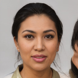 Joyful latino young-adult female with medium  brown hair and brown eyes