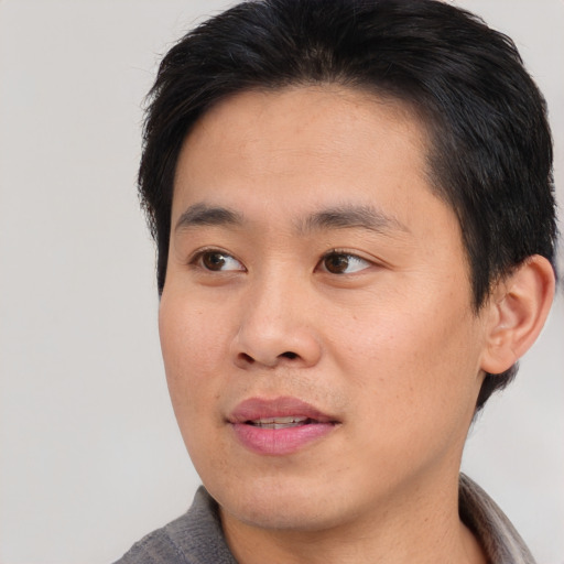 Joyful asian young-adult male with short  brown hair and brown eyes