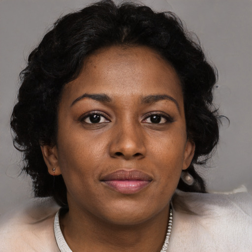 Joyful black adult female with long  brown hair and brown eyes