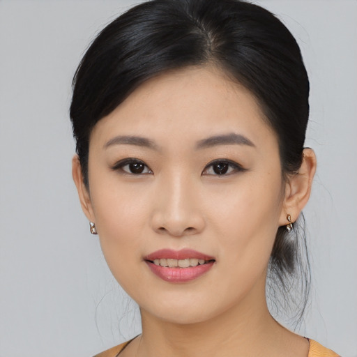Joyful asian young-adult female with medium  black hair and brown eyes