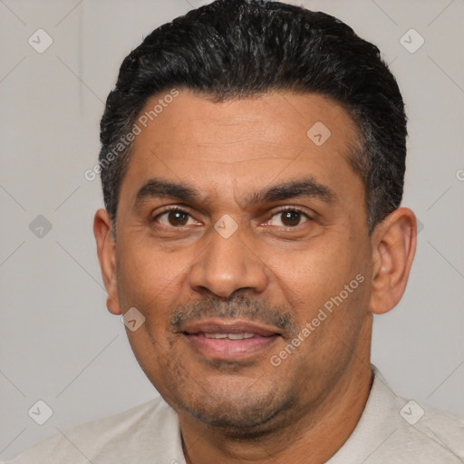 Joyful latino adult male with short  black hair and brown eyes