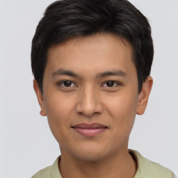 Joyful latino young-adult male with short  brown hair and brown eyes