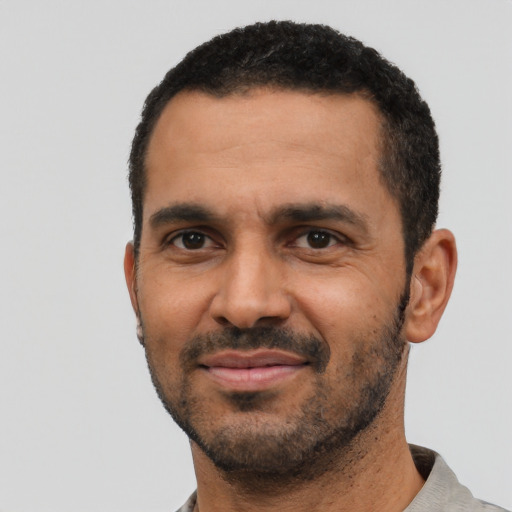 Joyful black adult male with short  black hair and brown eyes