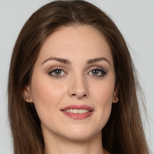 Joyful white young-adult female with long  brown hair and grey eyes