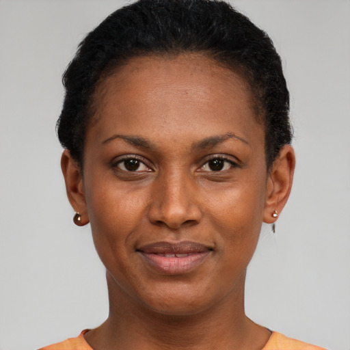 Joyful black young-adult female with short  black hair and brown eyes