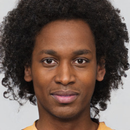 Joyful black young-adult male with short  brown hair and brown eyes