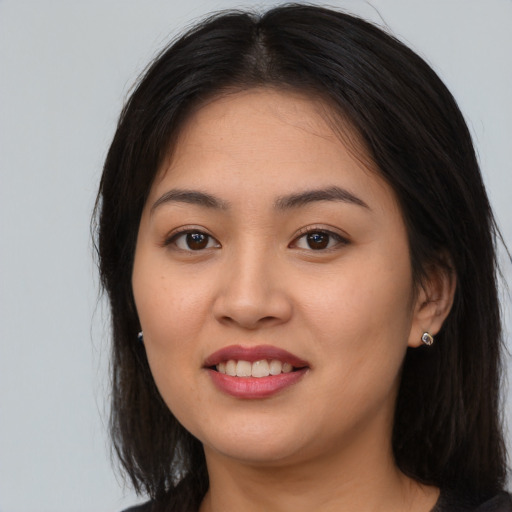 Joyful asian young-adult female with long  brown hair and brown eyes