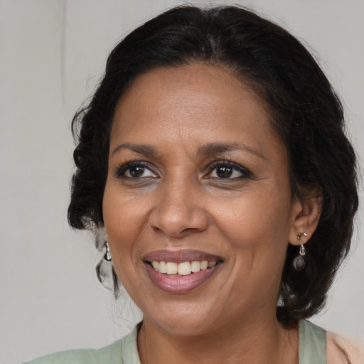 Joyful black adult female with medium  brown hair and brown eyes