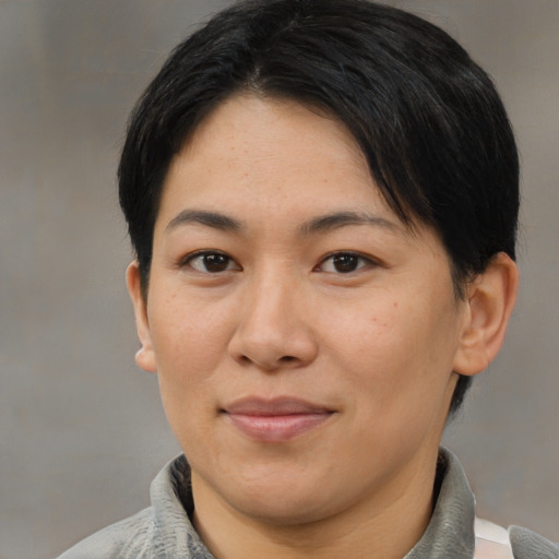 Joyful asian adult female with short  brown hair and brown eyes