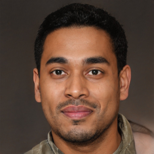 Joyful latino young-adult male with short  black hair and brown eyes