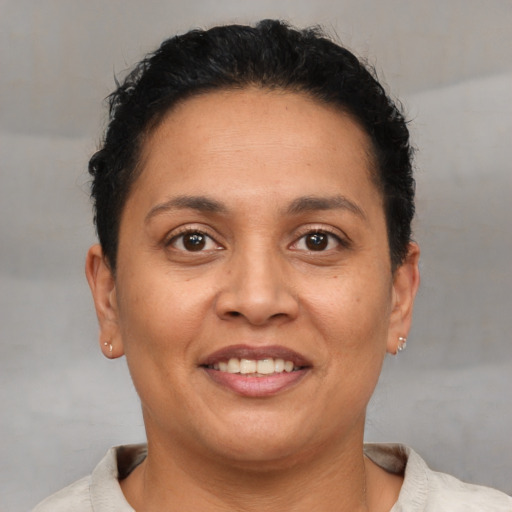 Joyful latino adult female with short  brown hair and brown eyes