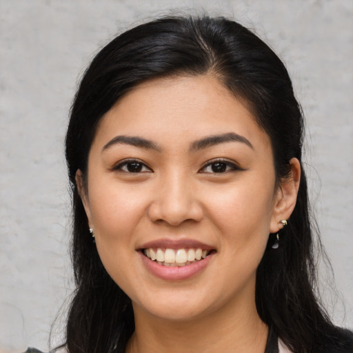 Joyful asian young-adult female with long  brown hair and brown eyes