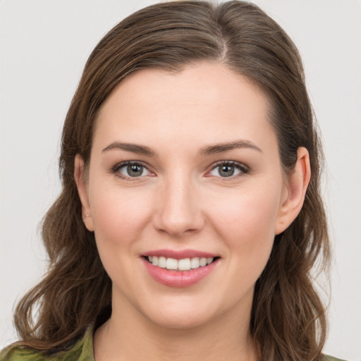 Joyful white young-adult female with long  brown hair and green eyes