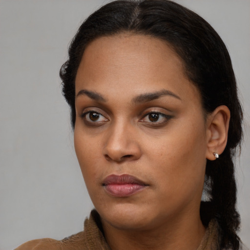 Joyful black young-adult female with long  brown hair and brown eyes