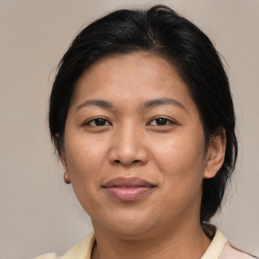 Joyful asian adult female with medium  brown hair and brown eyes
