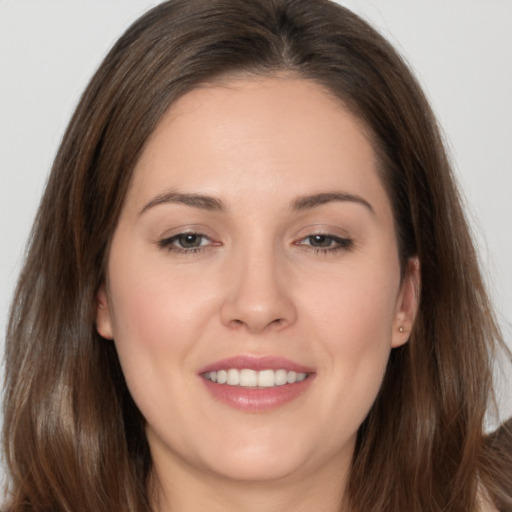 Joyful white young-adult female with long  brown hair and brown eyes