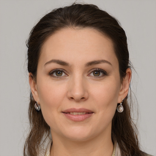 Joyful white young-adult female with medium  brown hair and grey eyes