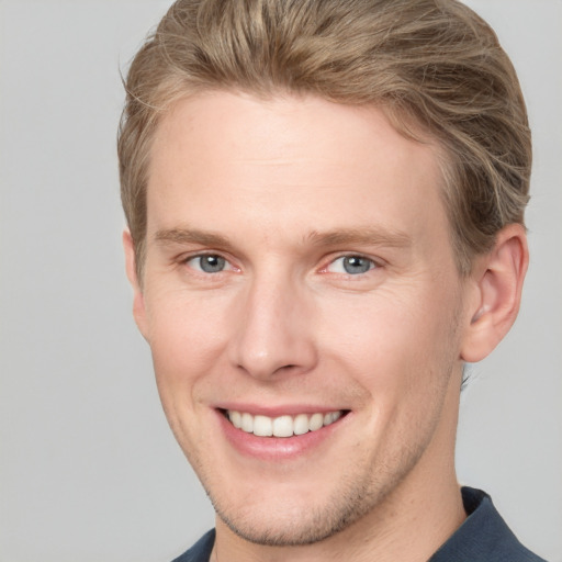 Joyful white young-adult male with short  brown hair and blue eyes