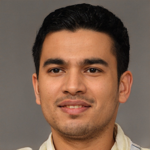 Joyful latino young-adult male with short  black hair and brown eyes