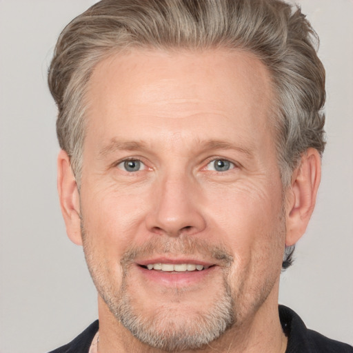 Joyful white adult male with short  brown hair and grey eyes