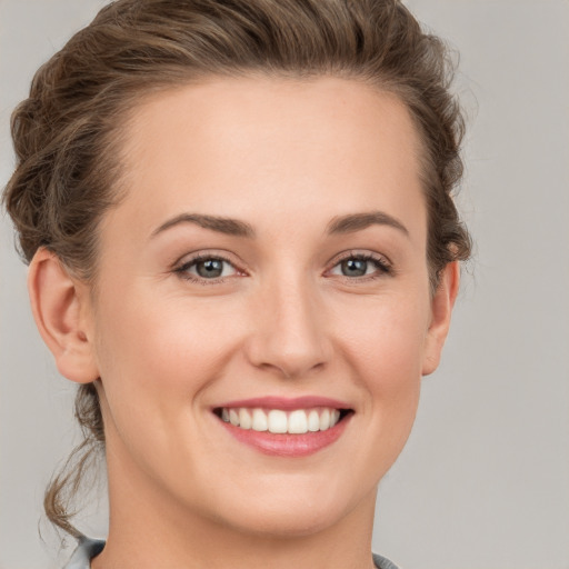 Joyful white young-adult female with short  brown hair and grey eyes