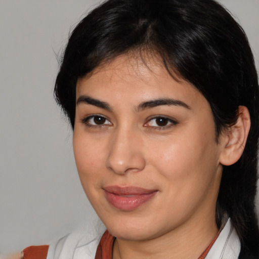 Joyful latino young-adult female with medium  brown hair and brown eyes