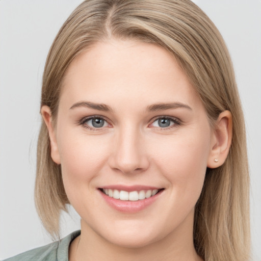 Joyful white young-adult female with medium  brown hair and grey eyes