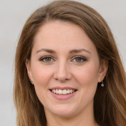 Joyful white young-adult female with long  brown hair and green eyes