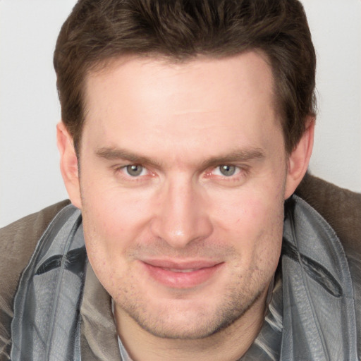 Joyful white adult male with short  brown hair and grey eyes