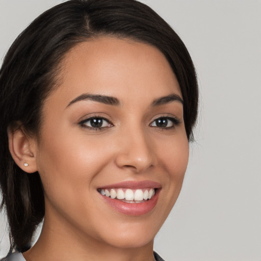 Joyful white young-adult female with medium  black hair and brown eyes