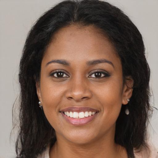 Joyful black young-adult female with long  brown hair and brown eyes