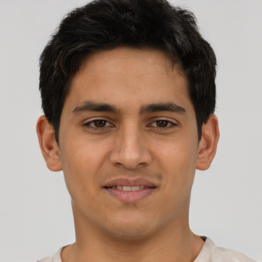 Joyful latino young-adult male with short  black hair and brown eyes