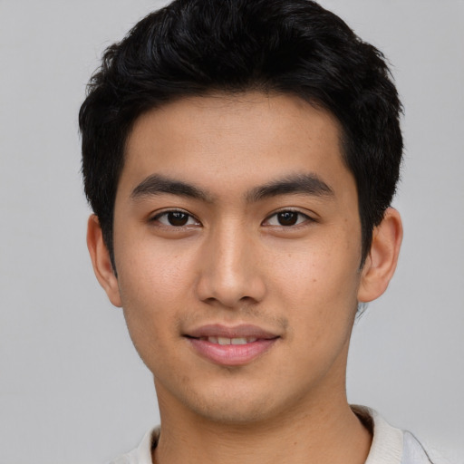 Joyful asian young-adult male with short  black hair and brown eyes