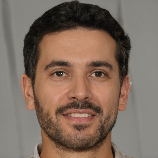 Joyful white young-adult male with short  black hair and brown eyes
