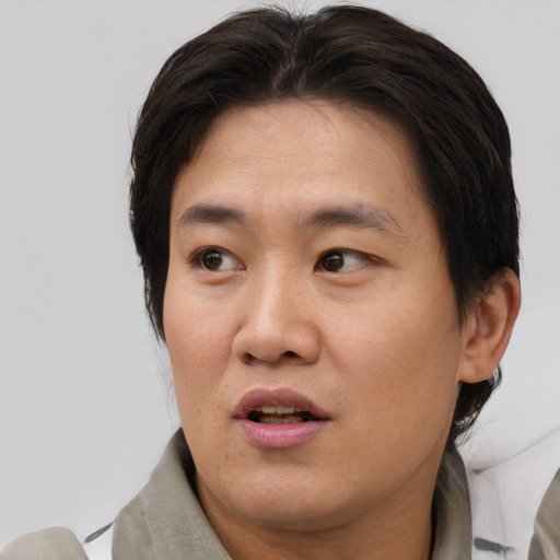 Joyful asian adult male with short  brown hair and brown eyes