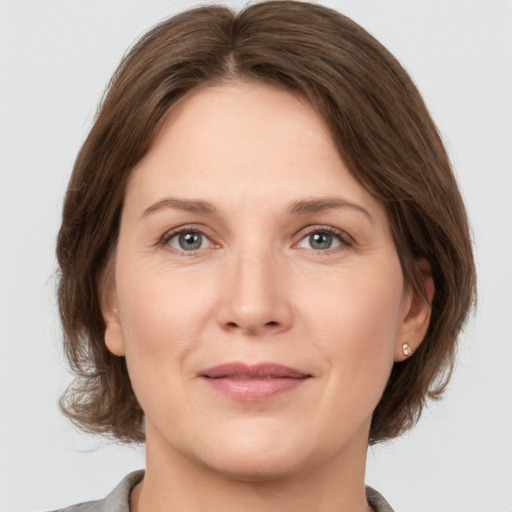 Joyful white adult female with medium  brown hair and grey eyes