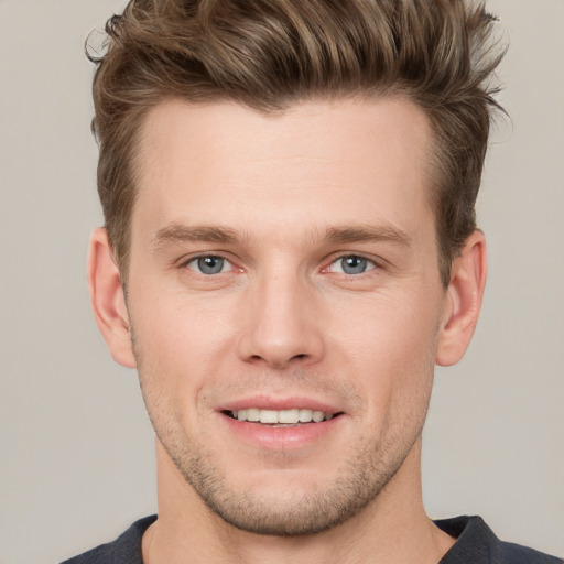 Joyful white young-adult male with short  brown hair and grey eyes