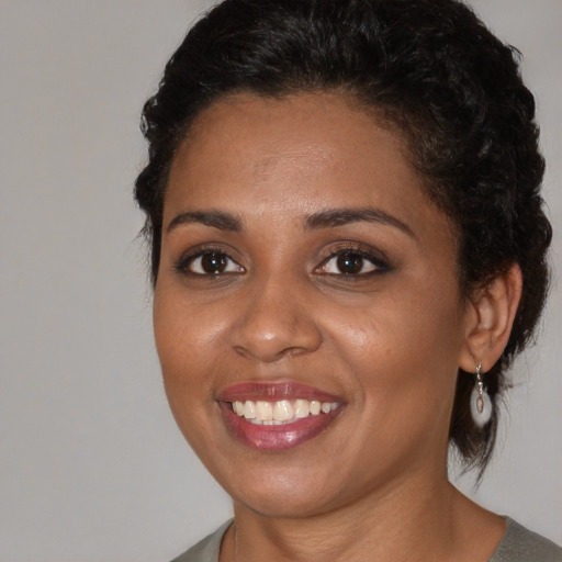 Joyful black young-adult female with medium  brown hair and brown eyes