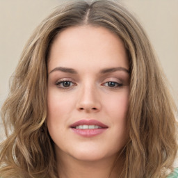 Joyful white young-adult female with long  brown hair and green eyes