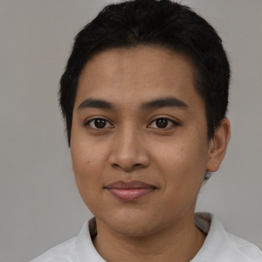 Joyful latino young-adult male with short  black hair and brown eyes